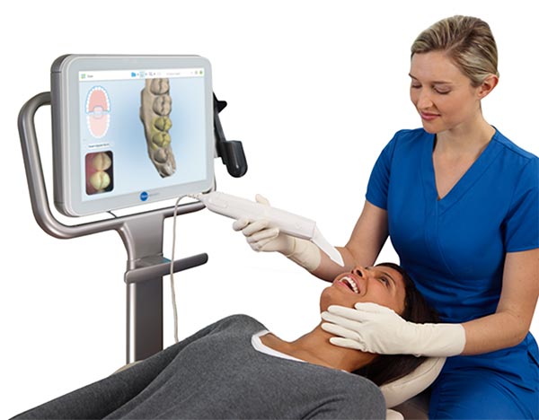 Dentist/dental assistant holding iTero intraoral scanner with patient on chair